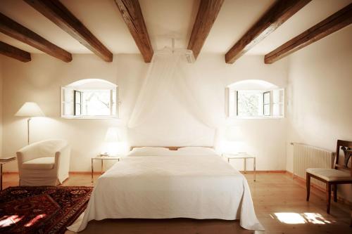 a bedroom with a white bed and two windows at Alter Winzerkeller in Kirchberg am Wagram