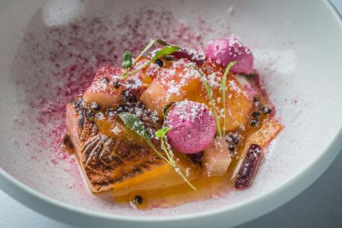 a white plate with a dessert with fruit on it at The Slaughters Manor House in Lower Slaughter