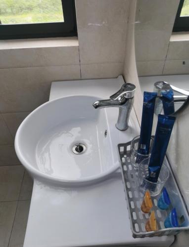 a bathroom sink with a toothbrush holder next to it at Junyao Inn in Huangshan