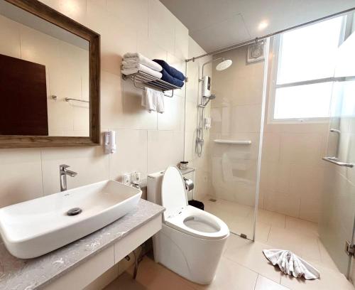 a bathroom with a sink and a toilet and a mirror at Charcoal Panwa Beach Phuket in Ban Tha Khreng