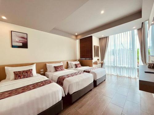 a hotel room with two beds and a window at Charcoal Panwa Beach Phuket in Ban Tha Khreng