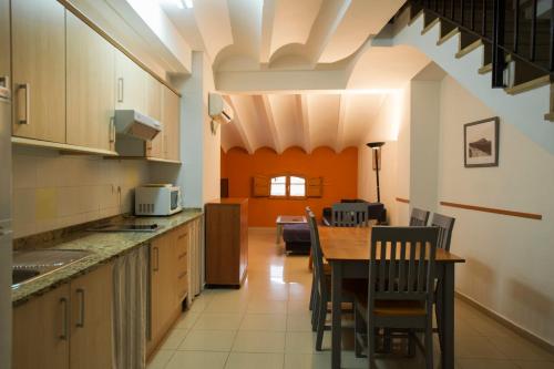 a kitchen with a table and a dining room at Complejo Rural La Belluga in Segorbe