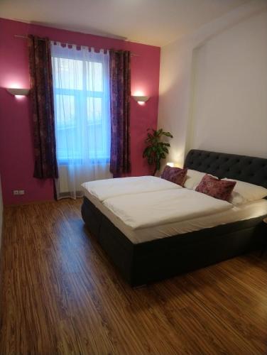 a bedroom with a large bed and a window at Luxusní byt v centru - Free Parking in Karlovy Vary