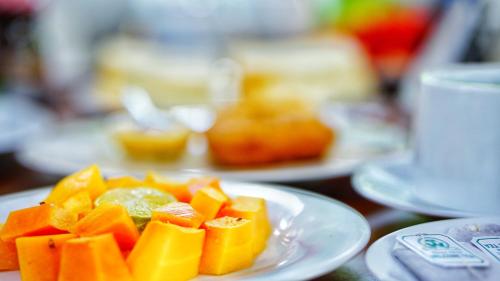 a white plate of fruit on a table at Dambulla Village Hotel & Restaurant in Dambulla
