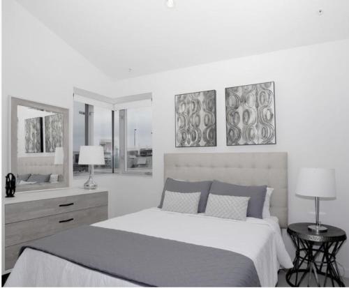 a bedroom with a bed with three pictures on the wall at Sea & Sky 2 Bed Escape Apt in Santa Monica with FREE PARKING in Los Angeles