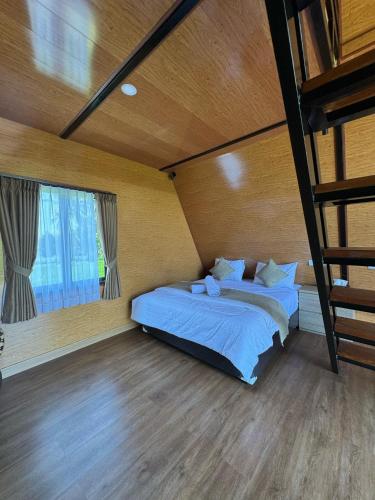 a bedroom with two beds and a loft at Lombok Hidden Villa in Tetebatu