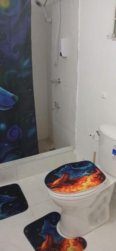 a bathroom with a toilet with a painting on the seat at Holiday Rooms St Thomas Jamaica full air-con in Port Morant