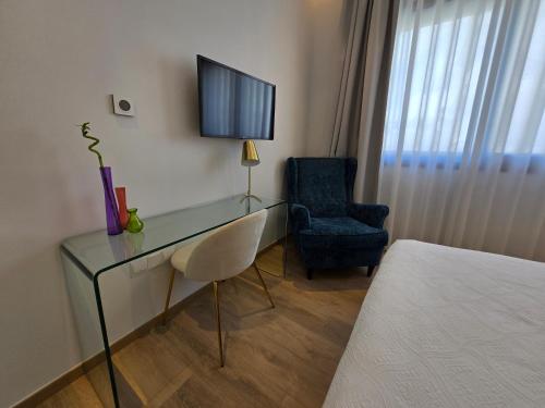 a room with a desk and a chair and a television at TG NEW Luxury Private Resort & SPA Villas - Heated Salty Swimming Pool, Outdoor Jacuzzi, Sauna, Exotic Garden in Limassol