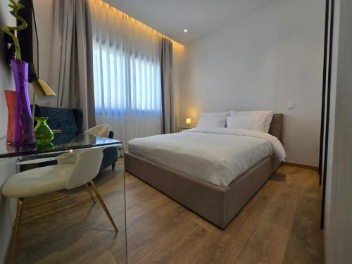 a bedroom with a bed and a table and a chair at TG NEW Luxury Private Resort & SPA Villas - Heated Salty Swimming Pool, Outdoor Jacuzzi, Sauna, Exotic Garden in Limassol