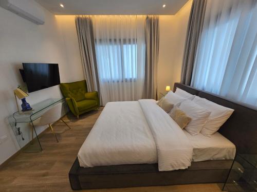 a bedroom with a large bed and a green chair at TG NEW Luxury Private Resort & SPA Villas - Heated Salty Swimming Pool, Outdoor Jacuzzi, Sauna, Exotic Garden in Limassol