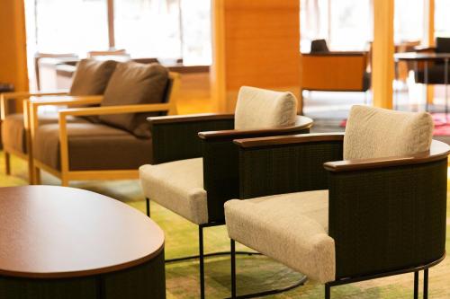 a group of chairs and tables in a room at Aso Baien Spa Resort in Minami Aso