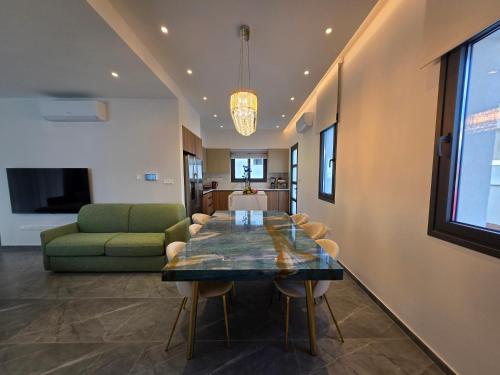 a dining room with a table and a green couch at TG NEW Luxury Private Resort & SPA Villas - Heated Salty Swimming Pool, Outdoor Jacuzzi, Sauna, Exotic Garden in Limassol