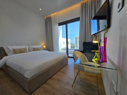 a bedroom with a bed and a glass table at TG NEW Luxury Private Resort & SPA Villas - Heated Salty Swimming Pool, Outdoor Jacuzzi, Sauna, Exotic Garden in Limassol