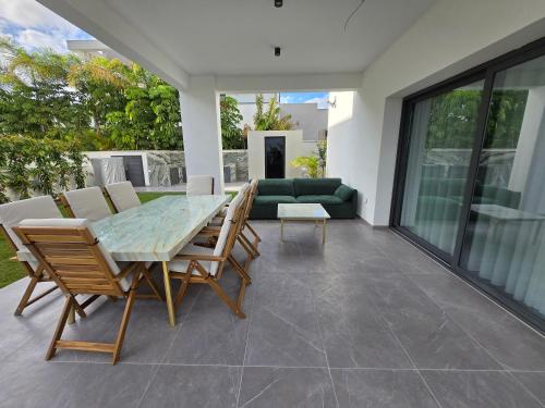 a patio with a glass table and chairs at TG NEW Luxury Private Resort & SPA Villas - Heated Salty Swimming Pool, Outdoor Jacuzzi, Sauna, Exotic Garden in Limassol