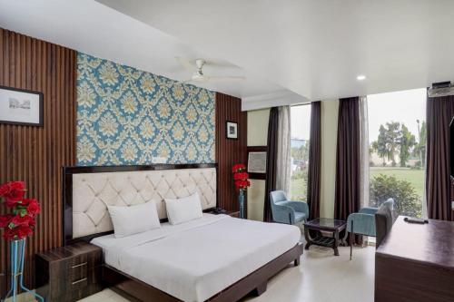 a bedroom with a white bed and a desk and chairs at JPS Residency & Hospitality Services in Gurgaon