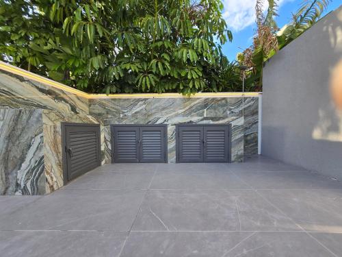 two metal garage doors in a stone wall at TG NEW Luxury Private Resort & SPA Villas - Heated Salty Swimming Pool, Outdoor Jacuzzi, Sauna, Exotic Garden in Limassol