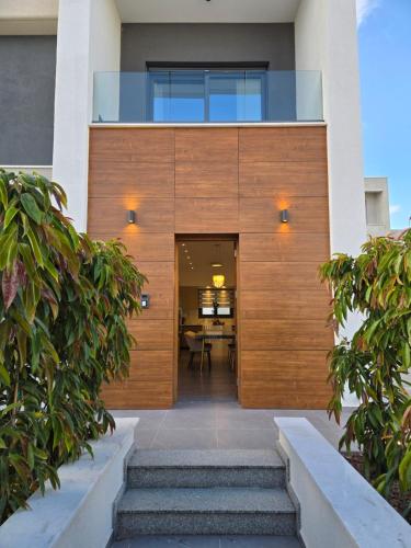 a house with a wooden door and stairs at TG NEW Luxury Private Resort & SPA Villas - Heated Salty Swimming Pool, Outdoor Jacuzzi, Sauna, Exotic Garden in Limassol