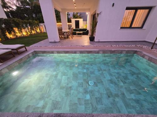 a swimming pool in the backyard of a house at TG NEW Luxury Private Resort & SPA Villas - Heated Salty Swimming Pool, Outdoor Jacuzzi, Sauna, Exotic Garden in Limassol