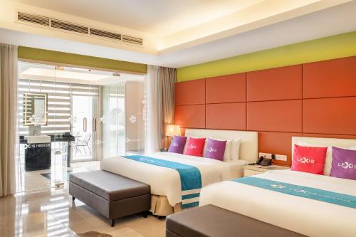 two beds in a hotel room with colorful walls at Lexis Hibiscus Port Dickson in Port Dickson