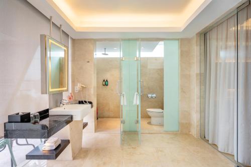 a bathroom with a shower and a sink and a toilet at Lexis Hibiscus Port Dickson in Port Dickson