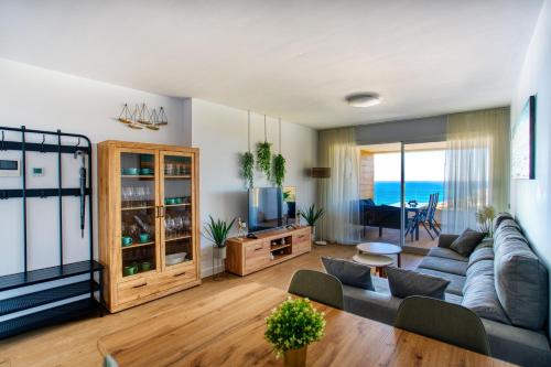 a living room with a couch and a television at New sunset views in Torrox Costa