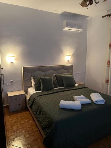 a bedroom with a large bed with two towels on it at Mayfair Apartment Ksamil in Ksamil