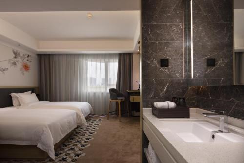 Postel nebo postele na pokoji v ubytování Paco Hotel Guangzhou Jiangtai Road Metro Branch - Free Shuttle Bus For Canton Fair