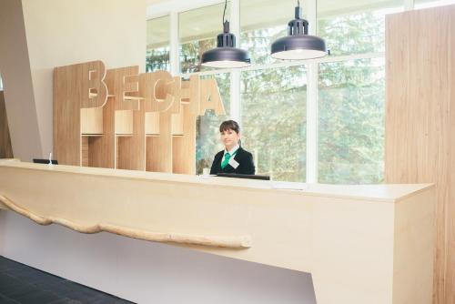 a man in a suit sitting at a reception desk at Hotel Vesna in Truskavets