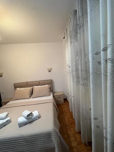 a bedroom with a bed with towels on it at Mayfair Apartment Ksamil in Ksamil