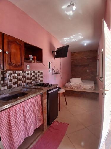 a kitchen with a sink and a stove top oven at Mini casa pé na areia in Ilhéus