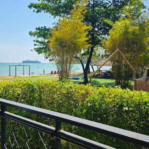 a park with a bench next to the beach at Charcoal Panwa Beach Phuket in Ban Tha Khreng