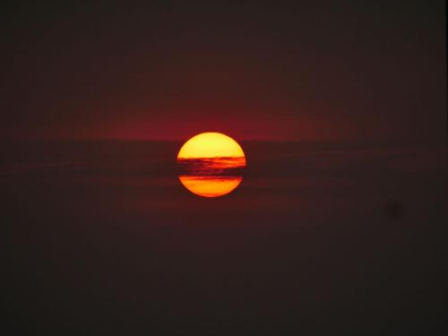 a sunset is seen through the clouds at JeeHaa Homestay in Alleppey