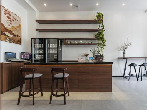 a wine bar with two stools in a room at ZhangJiaJie Enjoy Nature hotel in Hanqiyu