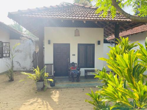 a house with a porch with a table and a chair at Kitelife Resort in Kalpitiya