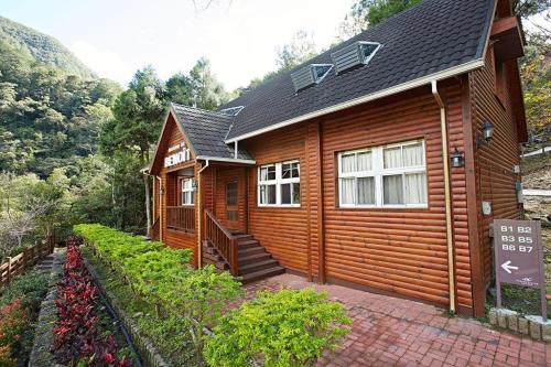 a wooden cabin with a porch and a sign in front of it at Taichung Business Hotel - Immortals Hills in Heping