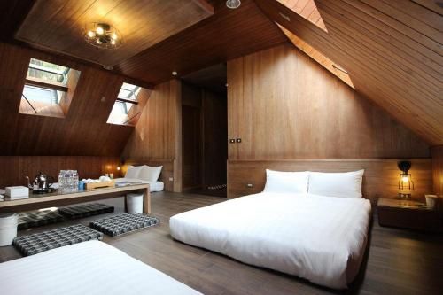 a bedroom with a large white bed and a desk at Taichung Business Hotel - Immortals Hills in Heping