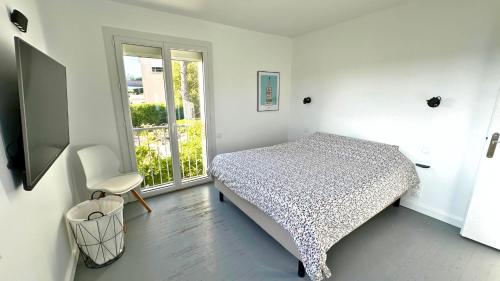 une chambre blanche avec un lit et une fenêtre dans l'établissement La Villa du Thym, Spacieuse villa familiale, piscine et vue dégagée, à Saint-Gély-du-Fesc