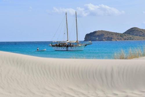 a sail boat in the water next to a beach at Giallo Limone in Teulada