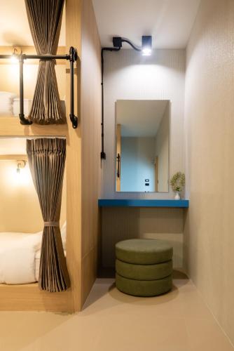 a bedroom with a mirror and a green stool at Kewalin hostel in Phi Phi Islands