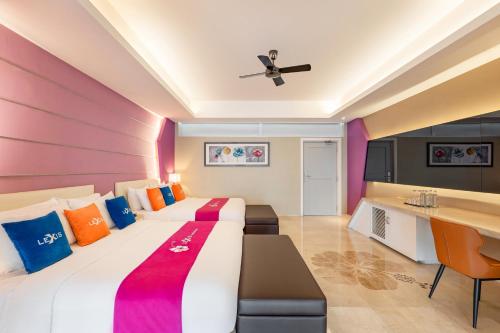 a hotel room with two beds and a desk at Lexis Hibiscus Port Dickson in Port Dickson