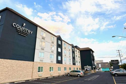 a building with a sign on the side of it at Country Inn & Suites by Radisson Rehoboth Beach - Dewey in Rehoboth Beach