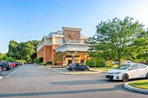 a hotel with cars parked in a parking lot at Comfort Inn & Suites Newark - Wilmington in Newark