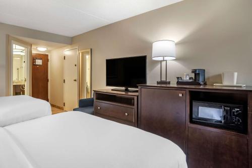 a hotel room with a bed and a flat screen tv at Comfort Inn & Suites Newark - Wilmington in Newark