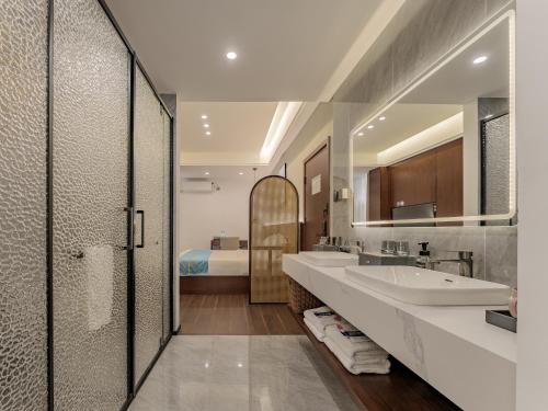 a bathroom with two sinks and a large mirror at ZhangJiaJie Enjoy Nature hotel in Hanqiyu