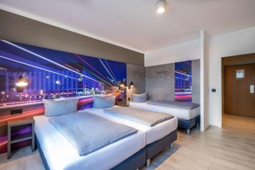 a hotel room with two beds and a large window at Hotel Berlin Lichtenberg in Berlin