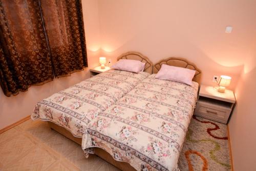 a bedroom with a bed with two tables and two lamps at Marinero Apartments in Kotor