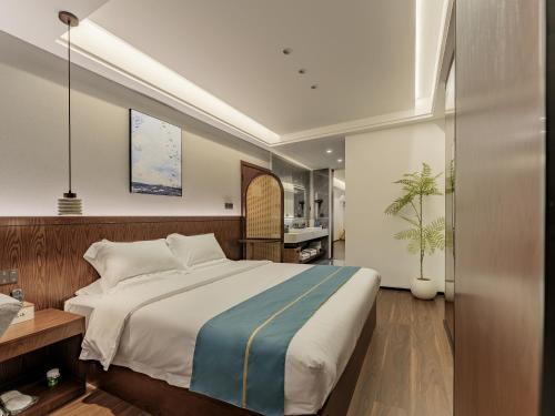 a bedroom with a large bed and a kitchen at ZhangJiaJie Enjoy Nature hotel in Hanqiyu