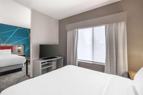 a hotel room with a bed and a tv at Comfort Suites Redmond Airport in Redmond
