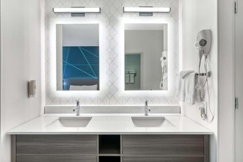a bathroom with two sinks and two mirrors at Comfort Suites Redmond Airport in Redmond