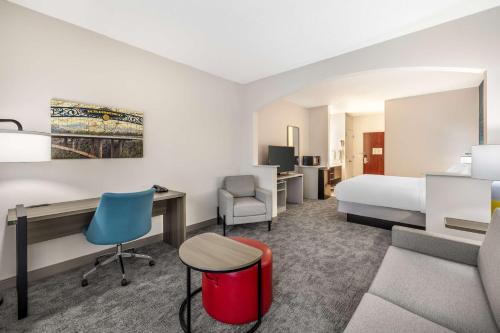 a hotel room with a bed and a desk and chair at Comfort Suites Redmond Airport in Redmond